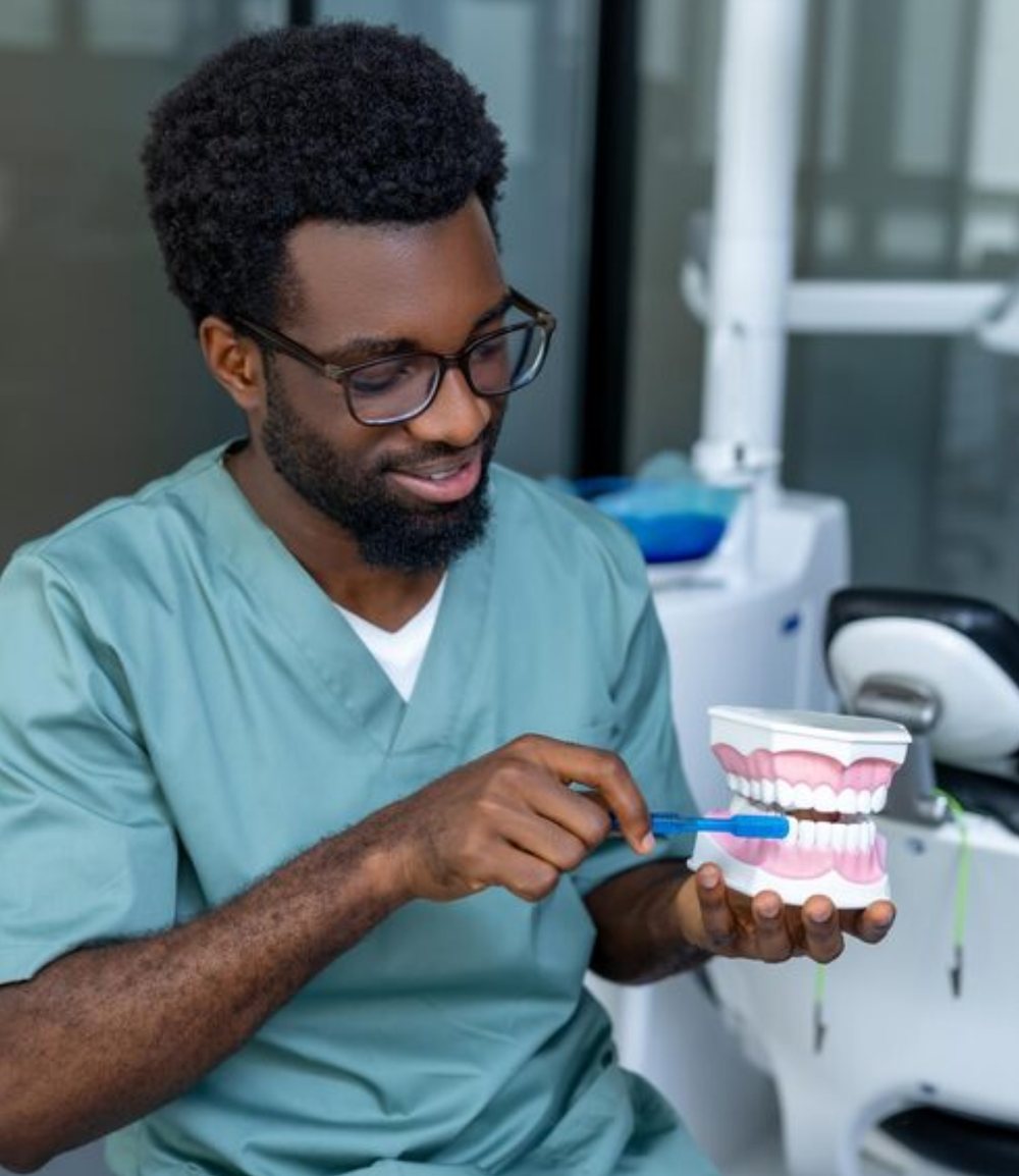 Dentist showing how to brush correctly on a dental model